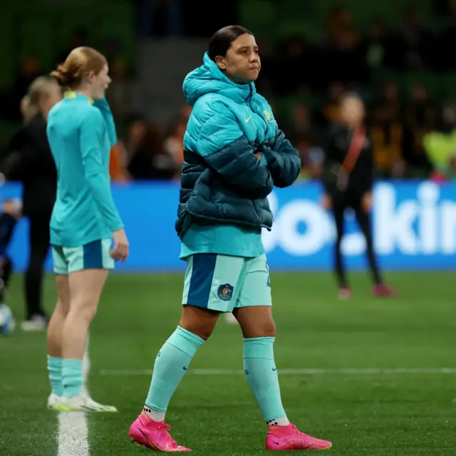 Sam Kerr stands and watches the Australia warm up.