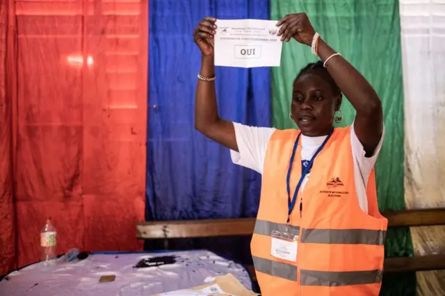 An employee of the national electoral agency shows a "yes" ballot paper, as the votes are counted following a referendum on a new constitution that would allow the president to seek a third term, at the Lycee Boganda in Bangui, on July 30, 2023.