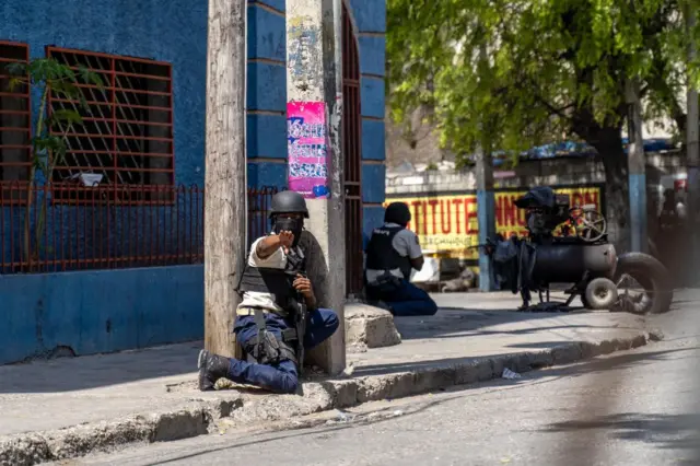 A Haitian National Police officer gestures as they attempt to repel gangs in a neighborhood near the Presidential Palace in the center of Port-au-Prince, Haiti on March 3, 2023