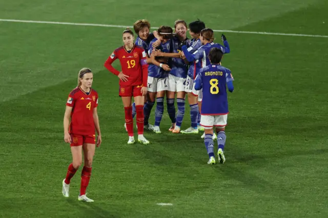 Japan players rush to celebrate together as Spain players stand shellshocked.