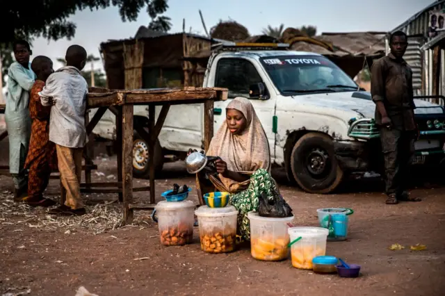 A woman selling food waits for costumers at Malkohi refugee camp in Jimeta, Adamawa State, Nigeria on February 19, 2019