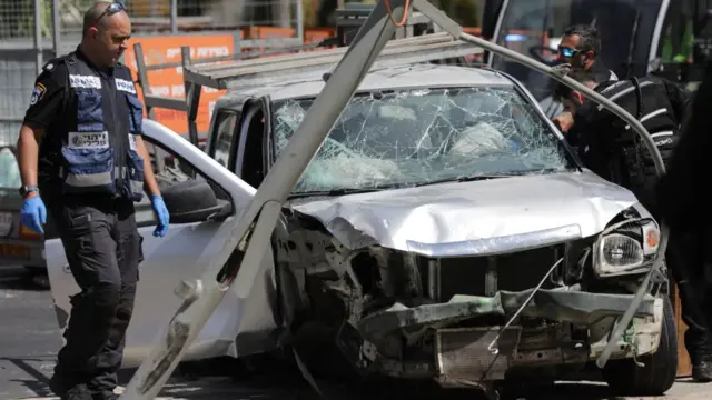 Israeli security and emergency personnel inspect the scene at he site of a car ramming attack in Tel Aviv