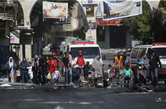 Members of Palestine Red Crescent Society (PRCS) help refugees to evacuate Jenin Camp