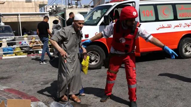 Members of Palestine Red Crescent Society (PRCS) help refugees to evacuate Jenin Camp