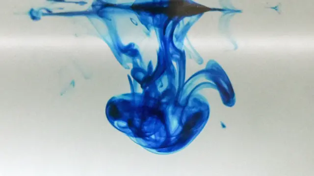 Drop of chemical methylene blue dissolving in water