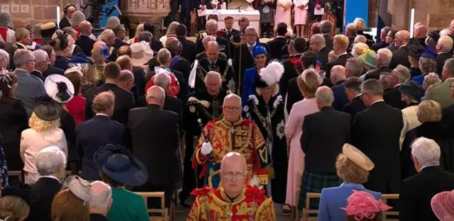 The King and Queen follow the clergy out of the cathedral