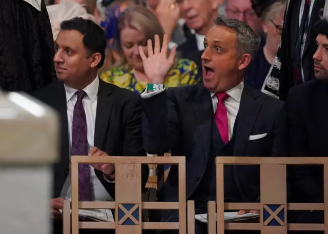 Scottish Liberal Democrats leader Alex Cole-Hamilton waves as he takes his seat at the service