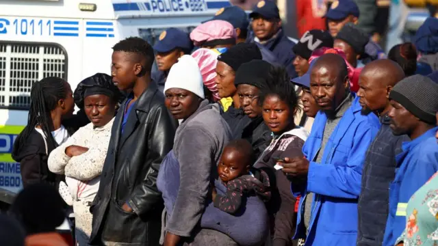Onlookers gather near the scene of a suspected gas leak thought to be linked to illegal mining, in the Angelo shack settlement, near Boksburg, east of Johannesburg, South Africa July 6, 2023