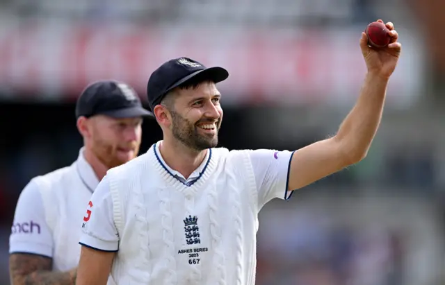 Mark Wood walks off holding the ball in the air after taking five wickets on the opening day of the third Ashes Test at Headingley