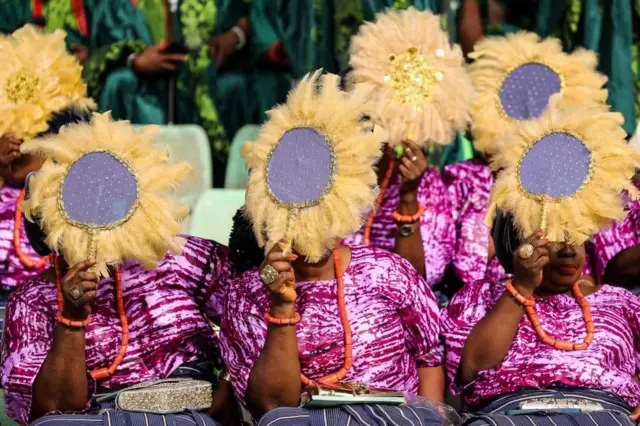 Women holding fans up