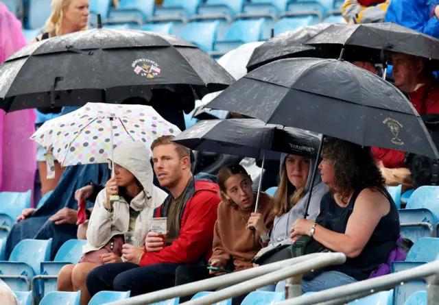 Spectators under umbrellas at Headingley