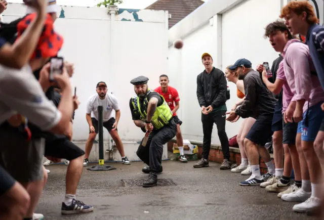 Police officer playing cricket with spectators at Headingley