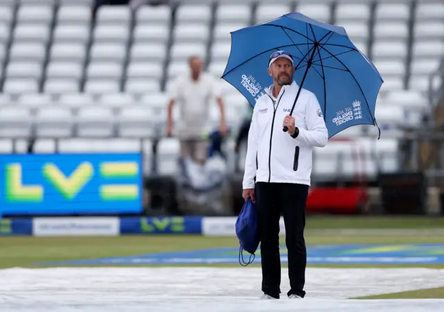 Umpire Mike Burns with an umbrella at Headingley this morning