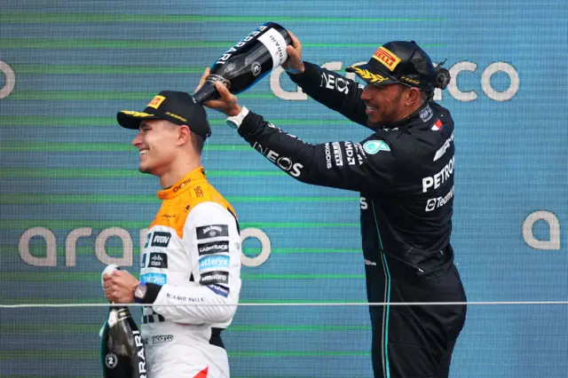 Lewis Hamilton pours champagne over Lando Norris' head