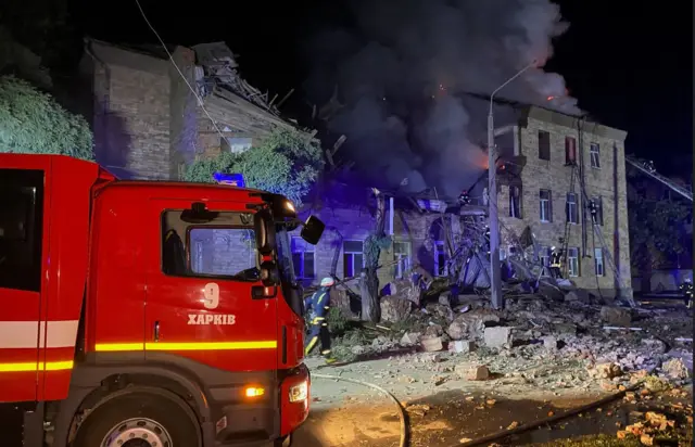 Firefighter truck by damaged building