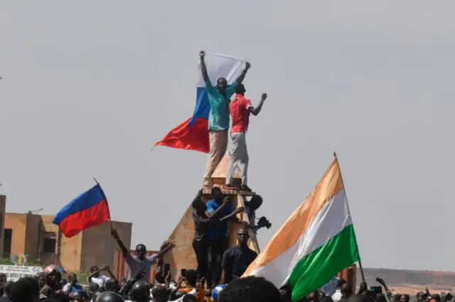 Protesters wave Nigerien and Russian flags as they gather during a rally in support of Niger's junta in Niamey on 30 July.