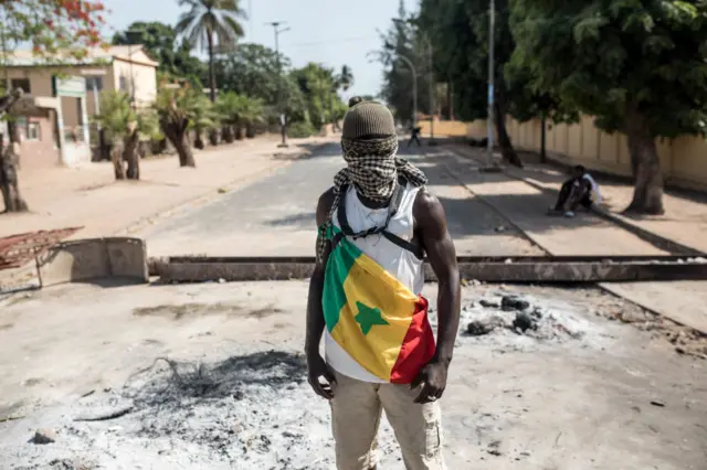 A protester wears the Senegalese national flag during a protest in Ziguinchor on May 16, 2023