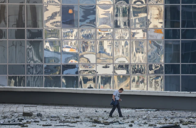 A man inspects rubble on the ground