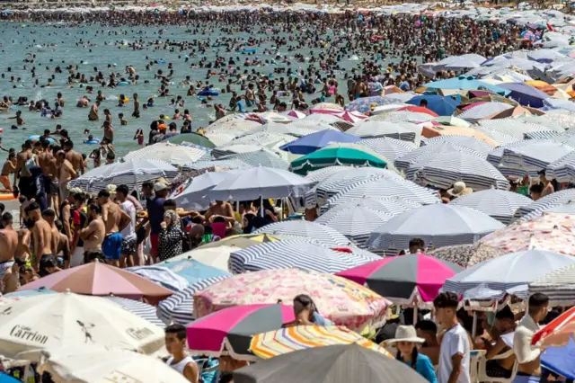 People gather at the beach in the city of M'diq during the 24th anniversary of Morocco's King Mohammed VI accession to the throne, on 30 July.