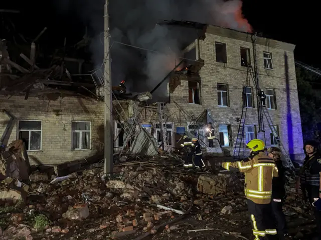 Rescuers work at a site of a building damaged by a Russian drone strike.