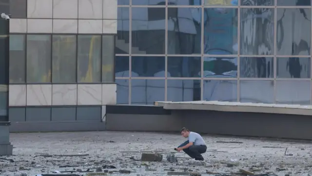 A man inspects debris on the ground