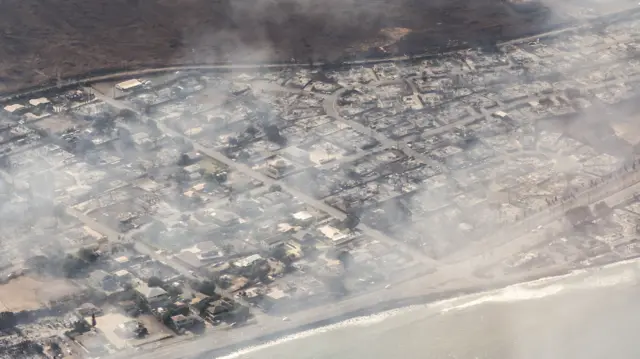 An aerial view of smoking buildings damaged in Lahaina, Maui as a result of a large wildfire