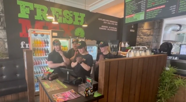 The staff at the FreshMex takeaway in Aberdeen applaud while watching a live stream