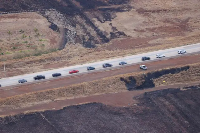 Cars drive away from Lahaina after wildfires