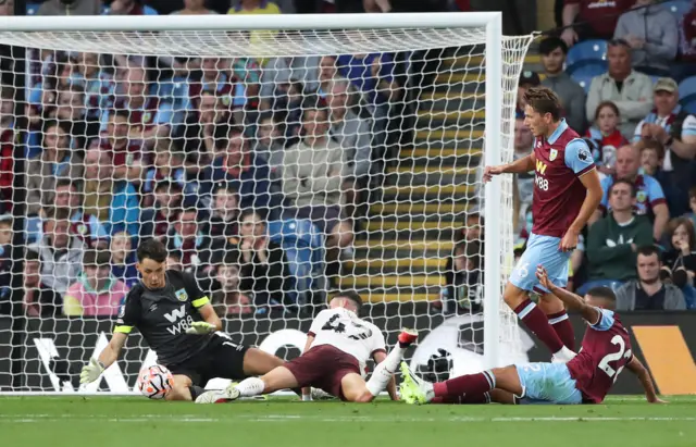 Foden tries to reach the ball on the ground as Trafford attempts to stop any potential shot.