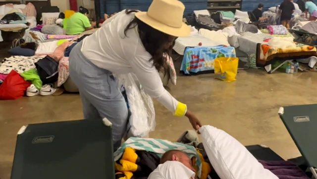 Oprah Winfrey handing out pillows and sheets to fire evacuees