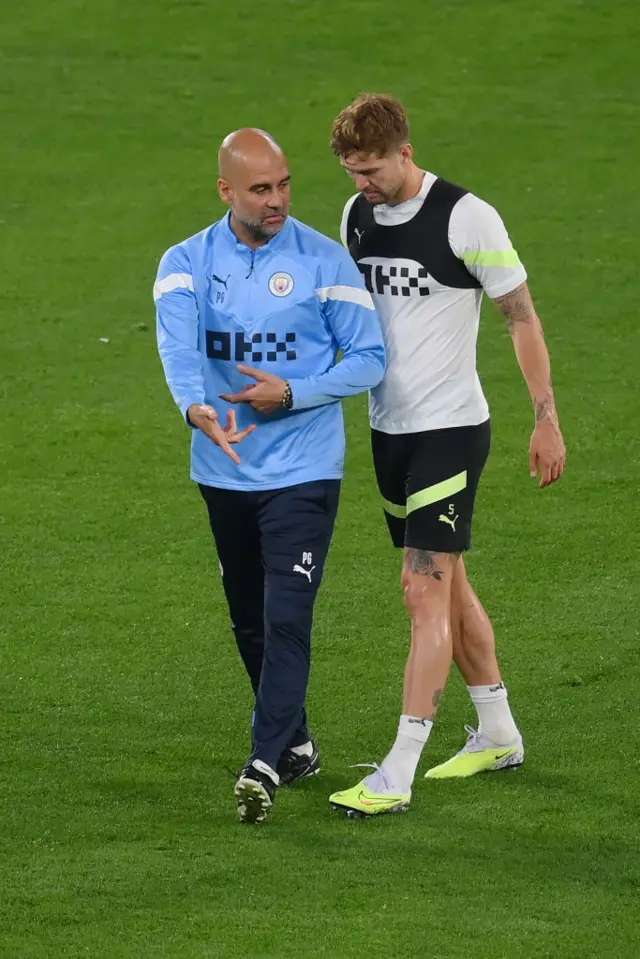 Guardiola gives Stones instructions in Man City training.