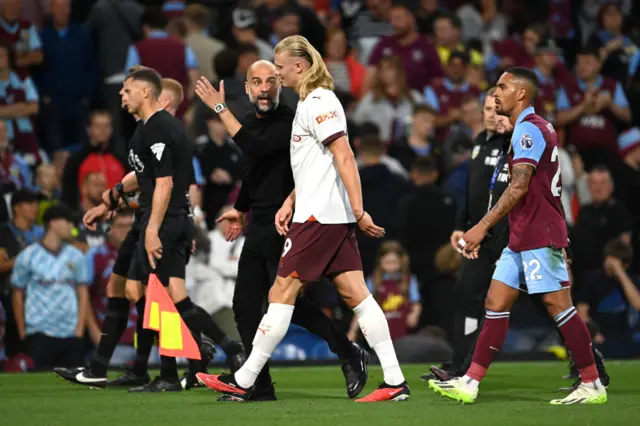 Guardiola and Haaland have a heated exchange as they head off the pitch.