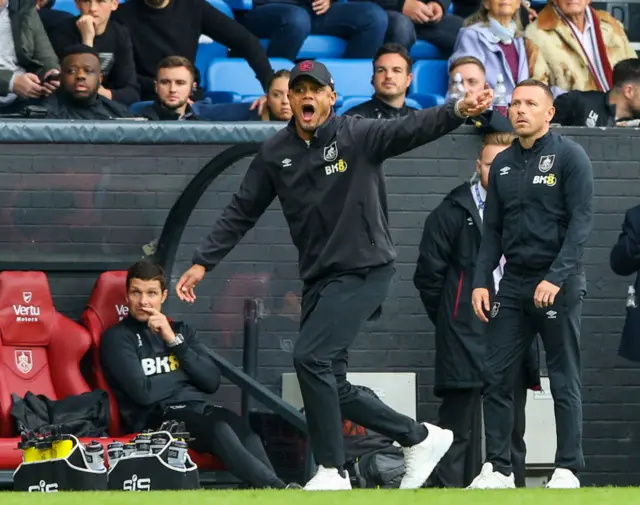 Vincent Kompany shouts instructions to his players from the dugout.