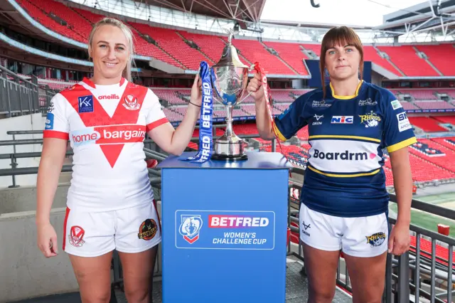 St Helens captain Jodie Cunningham and Leeds captain Hanna Butcher stand with the Challenge Cup at Wembley