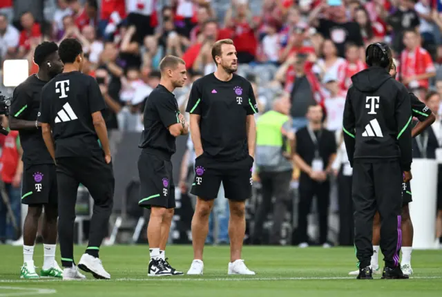 Harry Kane inspects the Allianz pitch with his new teammates.