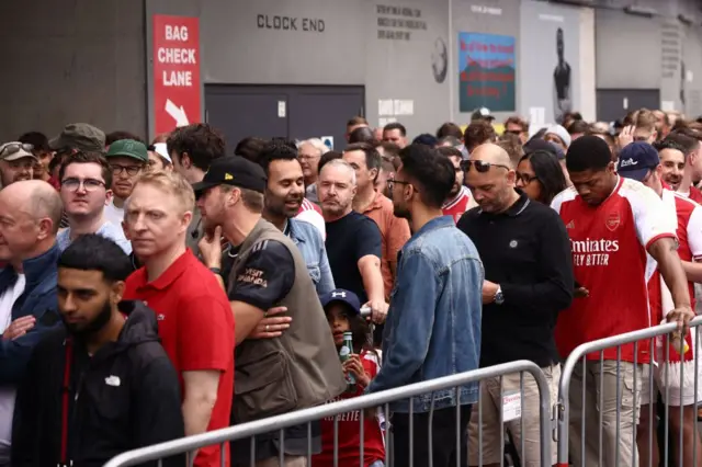 Fans continue to queue outside as the ticket system fails.