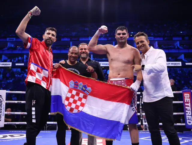 Filip Hrgovic celebrates with his team and a Croatia flag