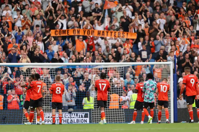 Luton players applaud the travelling fans at full time.