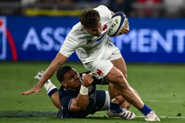 Scotland's Sione Tuipulotu tackles France's Damian Penaud