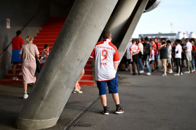 Fans look to prceed up the stairs decked in their Kane shirts.