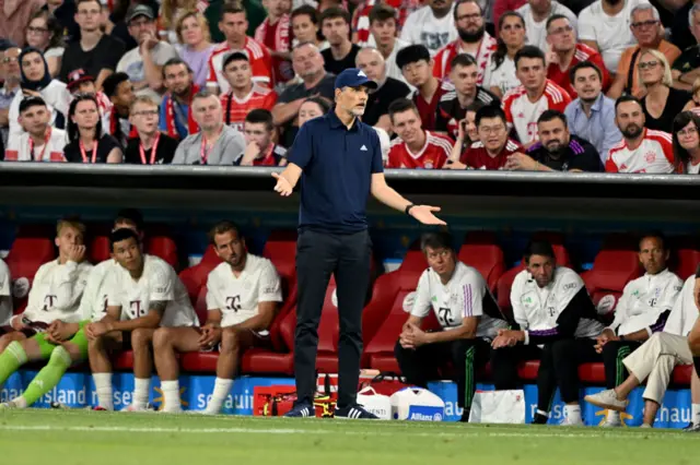 Tuchel stands with his hands up to complain about a decision.