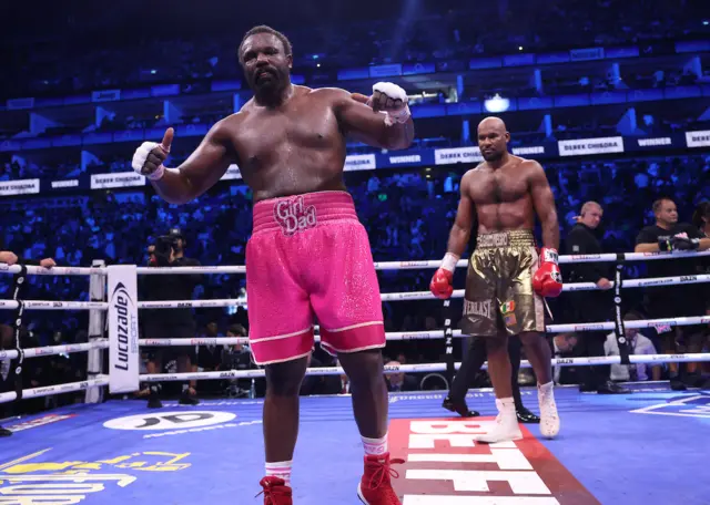 Derek Chisora gives a thumbs up with Gerald Washington in the background