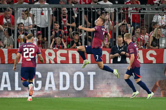 Olmo jumps in the air in celebration after opening the scoring, team mates run to celebrate with him.