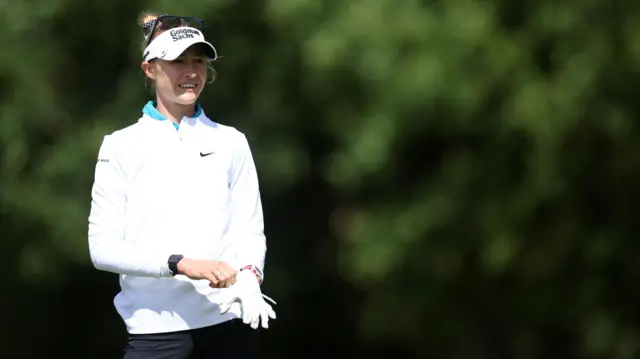 Nelly Korda puts on a glove