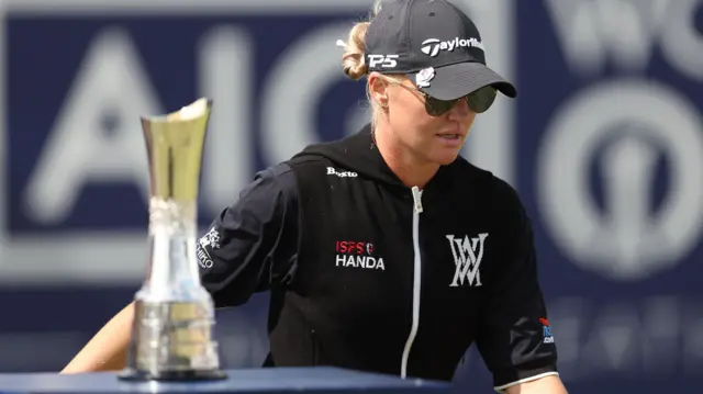 Charley Hull walks past the Women's Open trophy