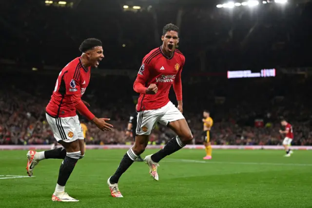 Varane and Sancho run to the corner to celebrate.