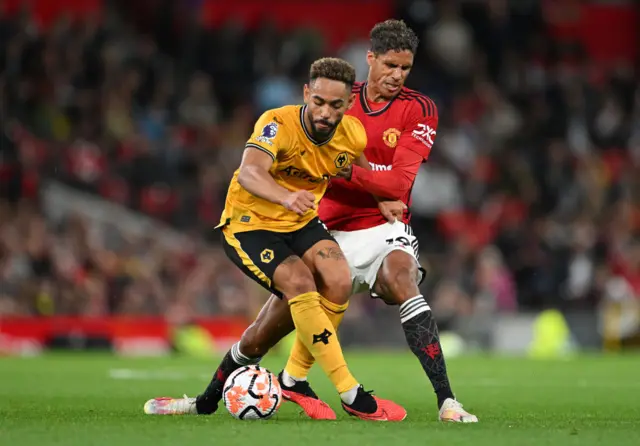 Cunha holds off a challenge from Varane.