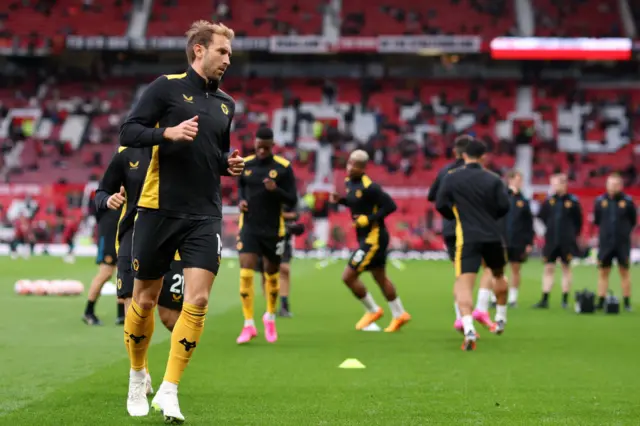 Wolves players warm up on the Old Trafford pitch.