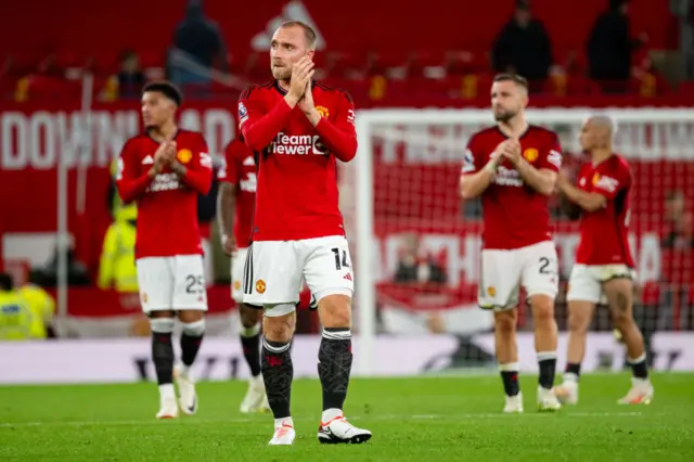 United players applaud the fans in relief after their narrow win.