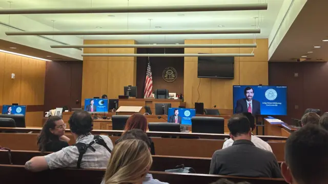 Journalists wait in the Fulton County courthouse